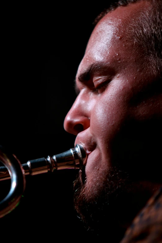 a man with a beard playing the trumpet