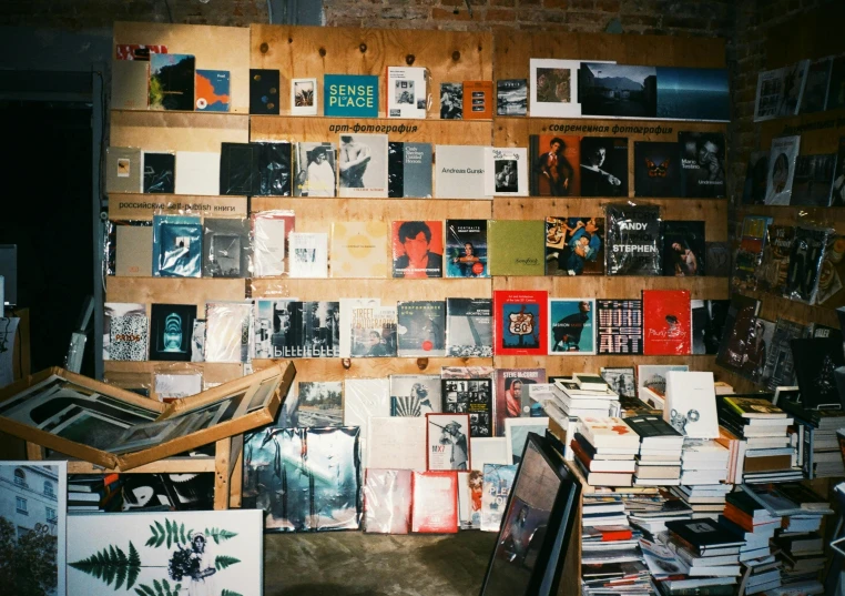 various books on wooden walls next to a painting