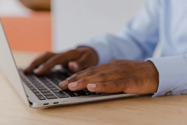 a man using his computer at a wooden table