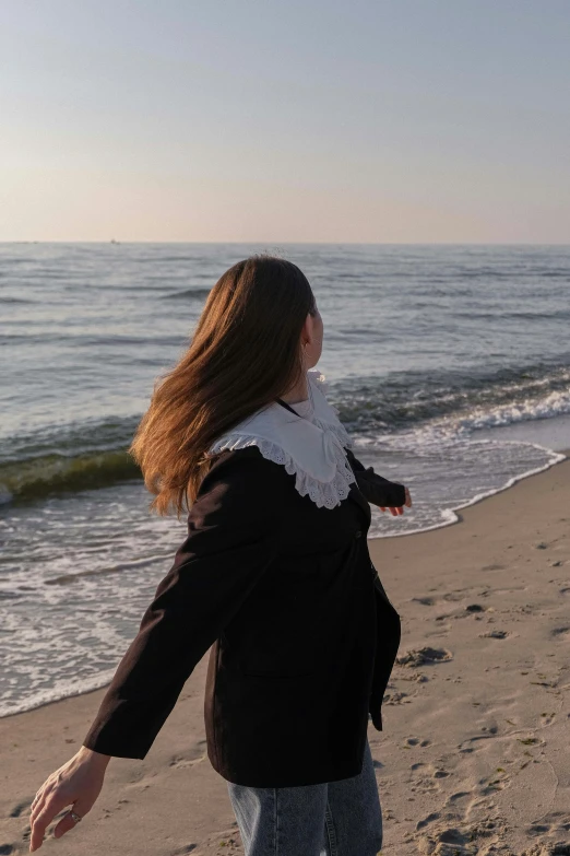 a woman on the beach looking at the water