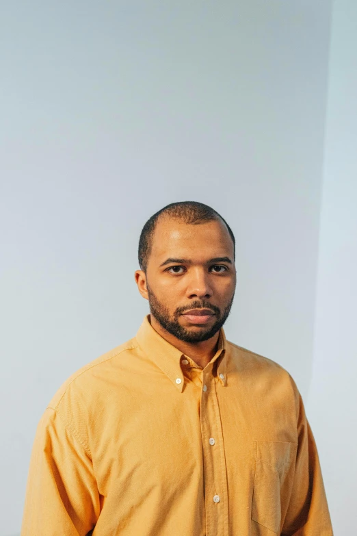 a man in a shirt is leaning against a wall