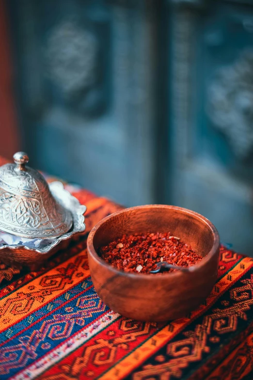 a bowl filled with chili sits on a colorful tablecloth