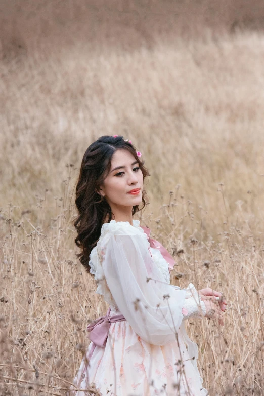 a woman in white is standing in the grass