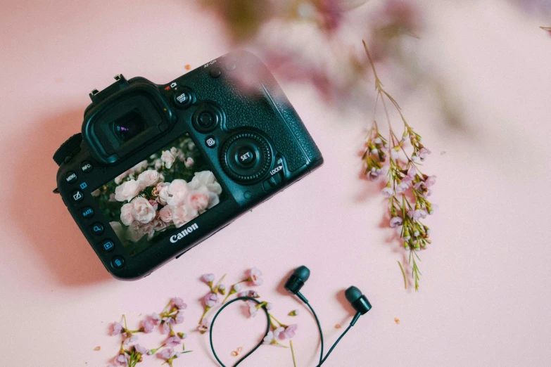 an open camera lens with flower headphones on top of it