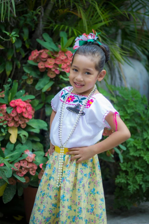 the child is wearing a frilly frilly dress with an attached flower headpiece