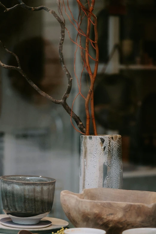 the bowl is sitting next to the vase and other items