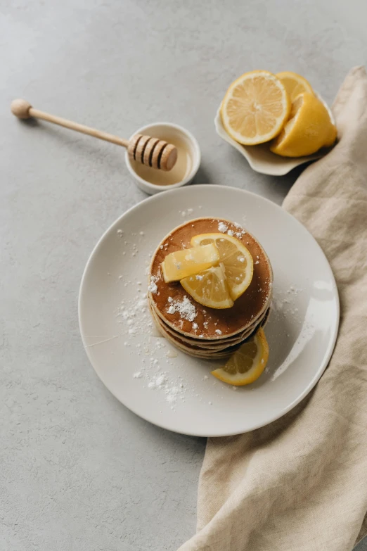 this is an image of pancakes with syrup and lemon slices