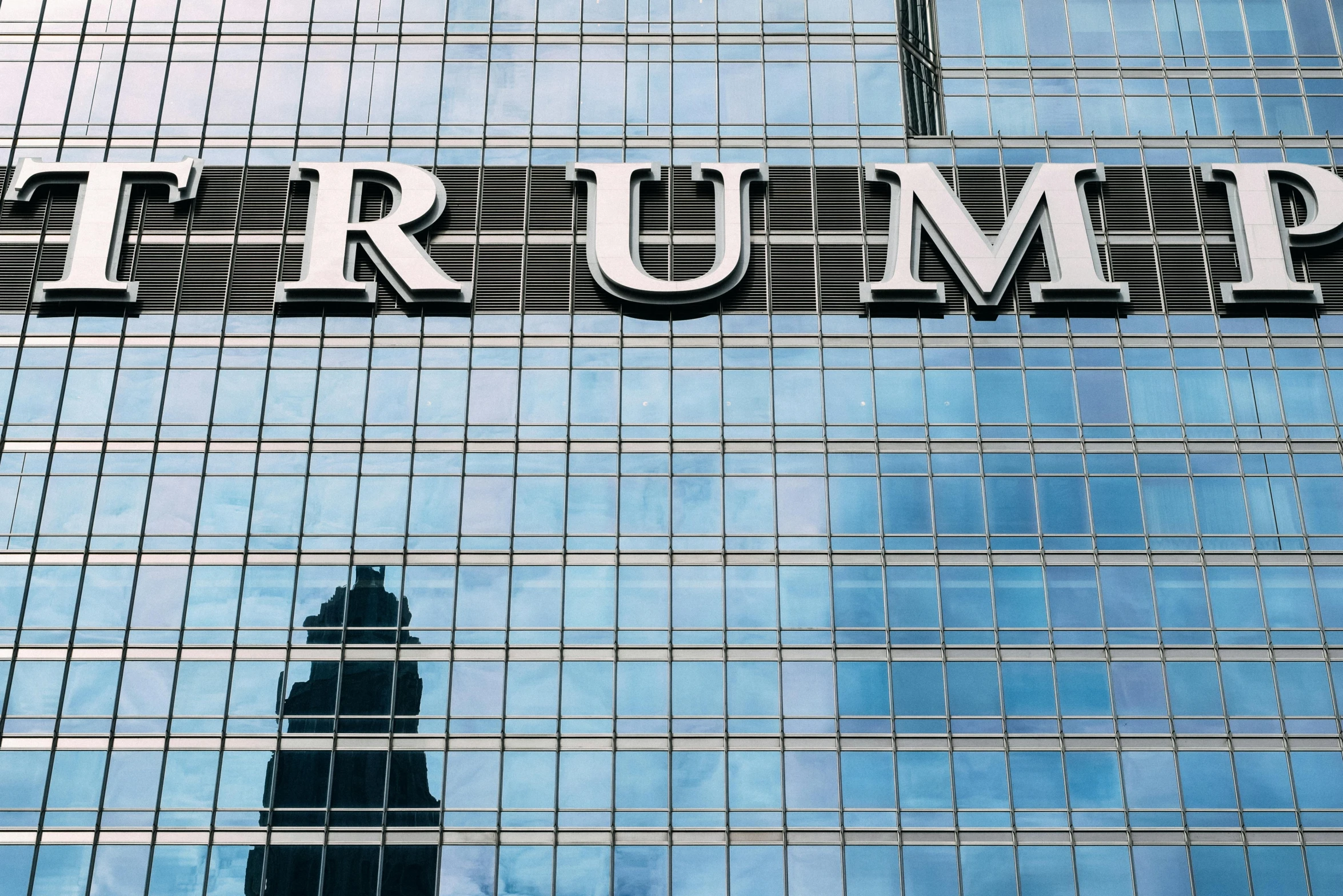 a clock tower stands outside the trump building