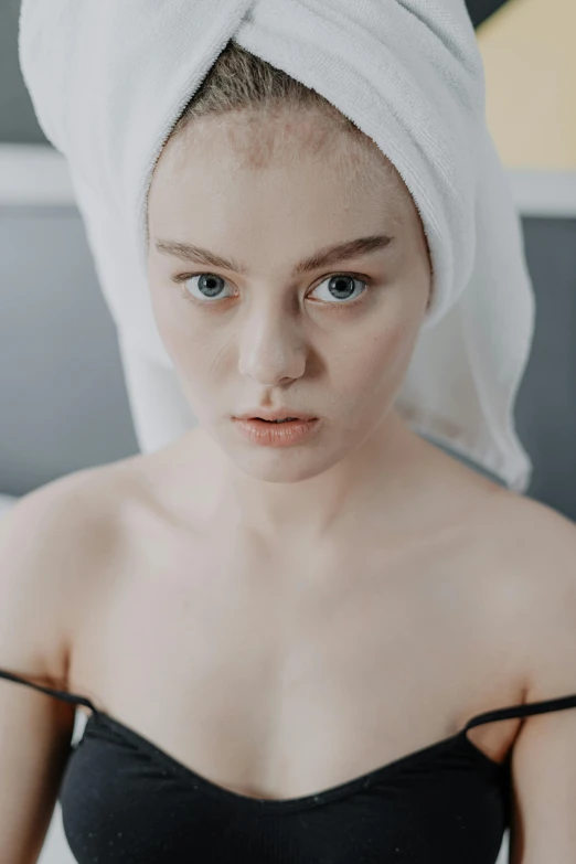 a woman with a towel on her head in bed