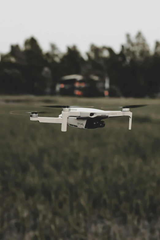 a white camera control flying over the grass