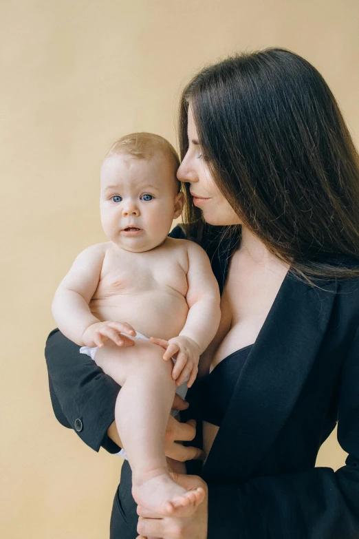 an adult holds up a baby in the air