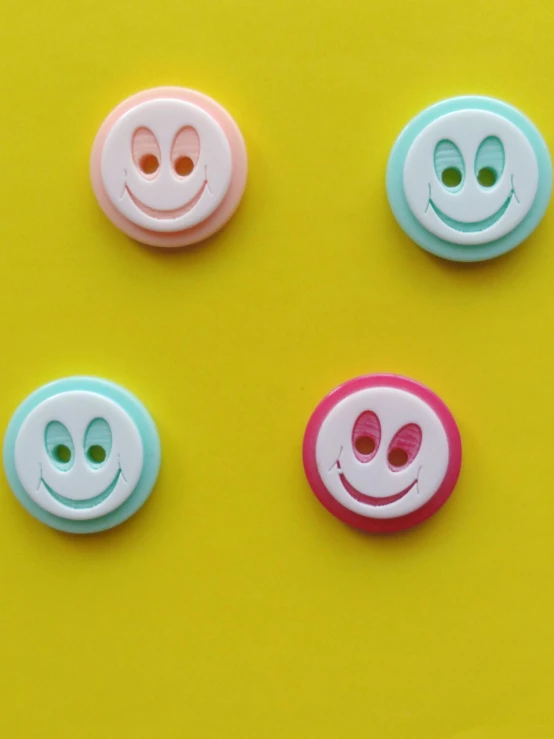 three brightly colored ons on a yellow surface