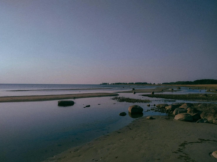 a body of water with rocks at the edge