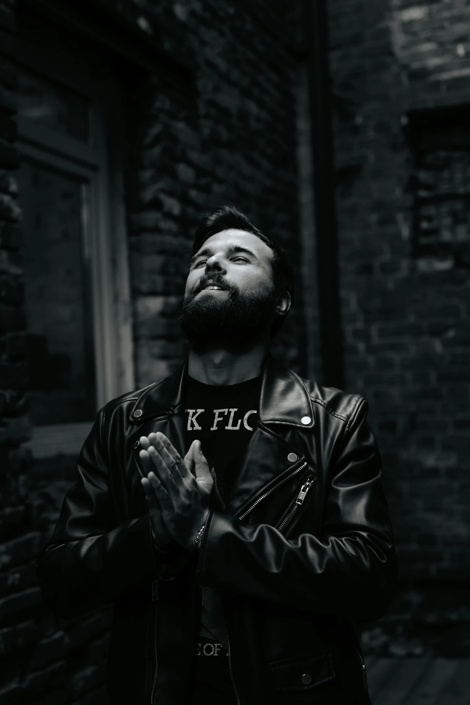 man standing with hand folded in prayer wearing jacket