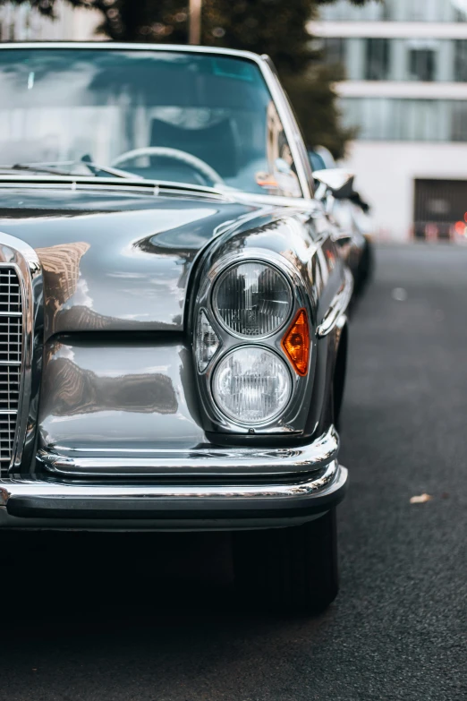 the front end of a black car on a street