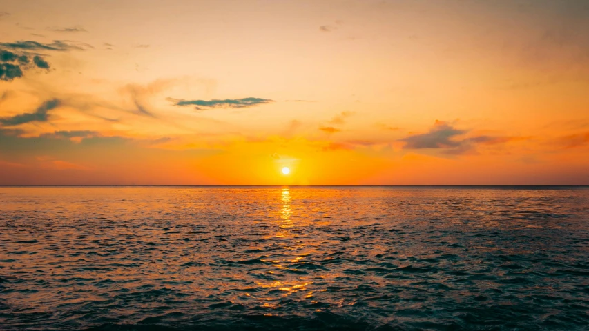 a sunset over the ocean at the beach