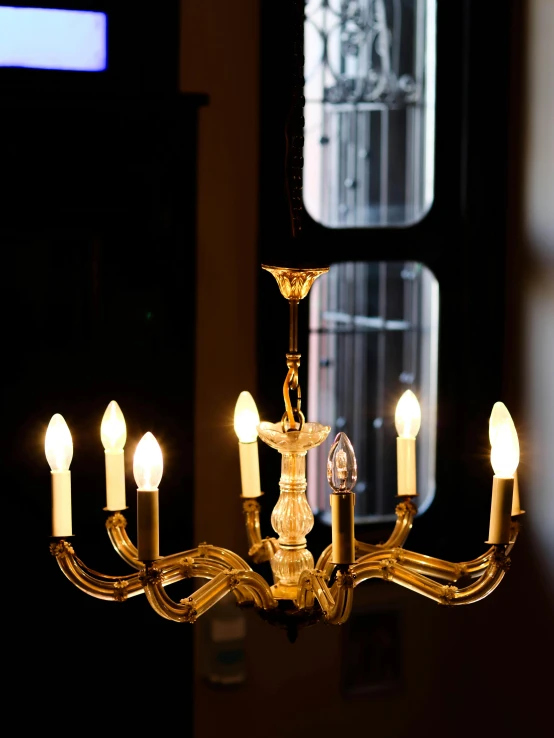 some white candles are on a small chandelier