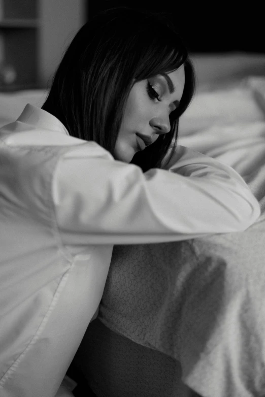 black and white po of woman laying on bed with her face resting on a plate