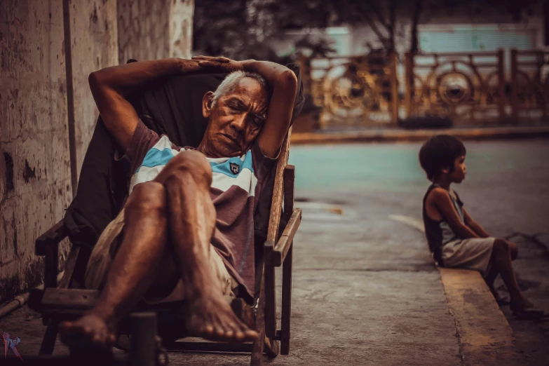 an old man in a chair next to his grandson