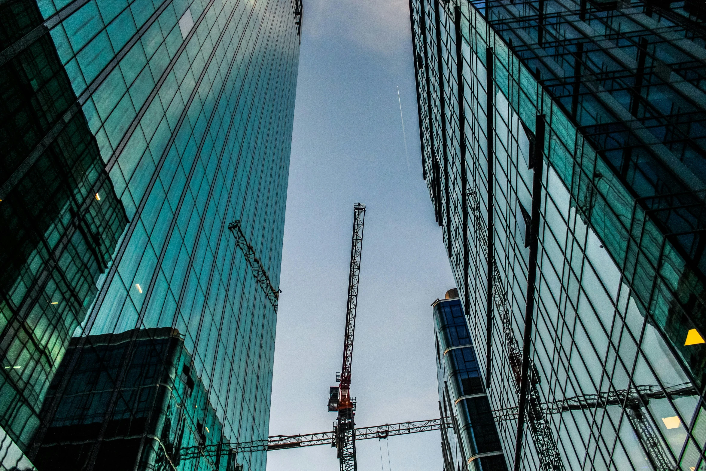 the view from below looking up at cranes and skyscrs