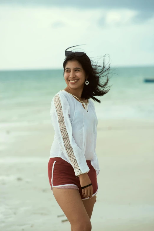 a woman smiling and holding her long hair