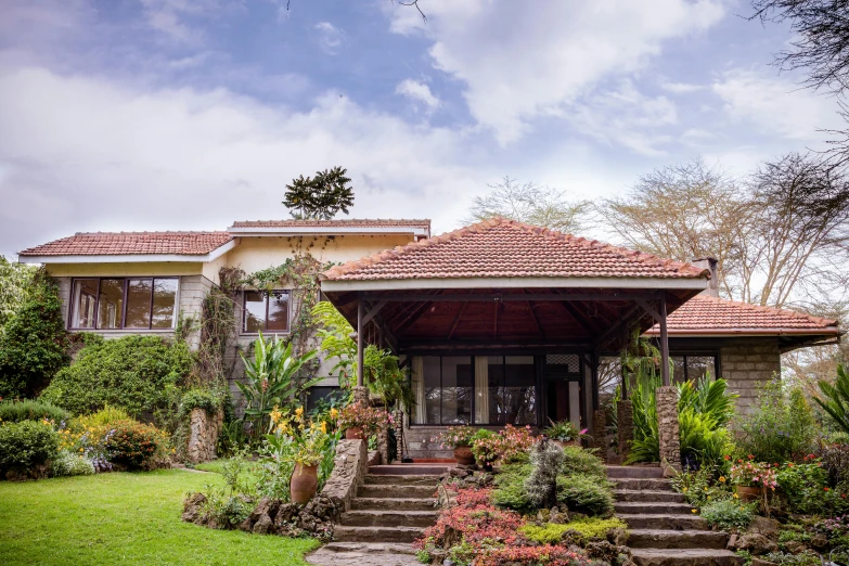 a beautiful house with a lush green yard and some stairs