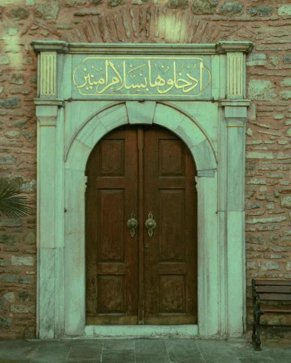 there is an old style arch above the brown doors