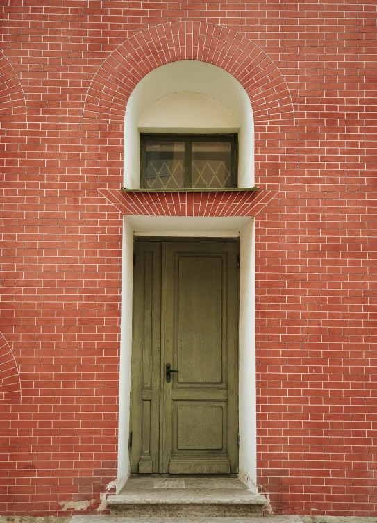 the door to a brick building with arched window