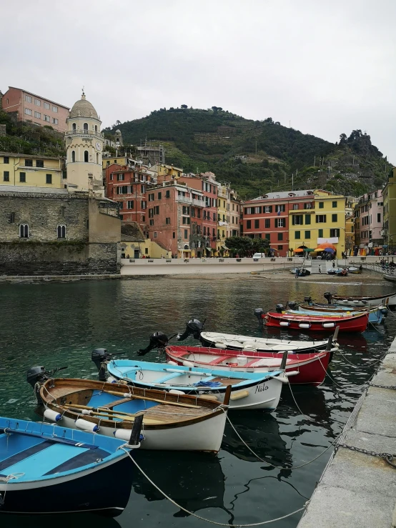 five boats tied to the shore in front of a village