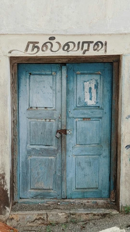 a blue door on a white house with graffiti and writing