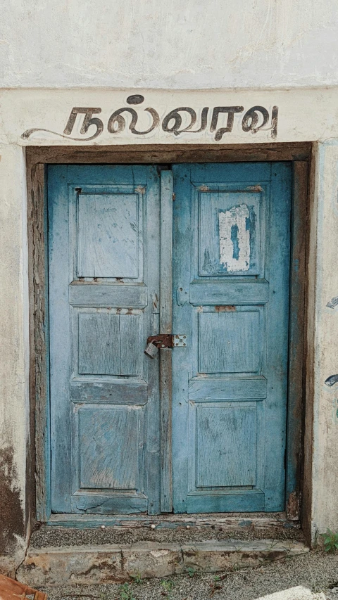 a blue door on a white house with graffiti and writing