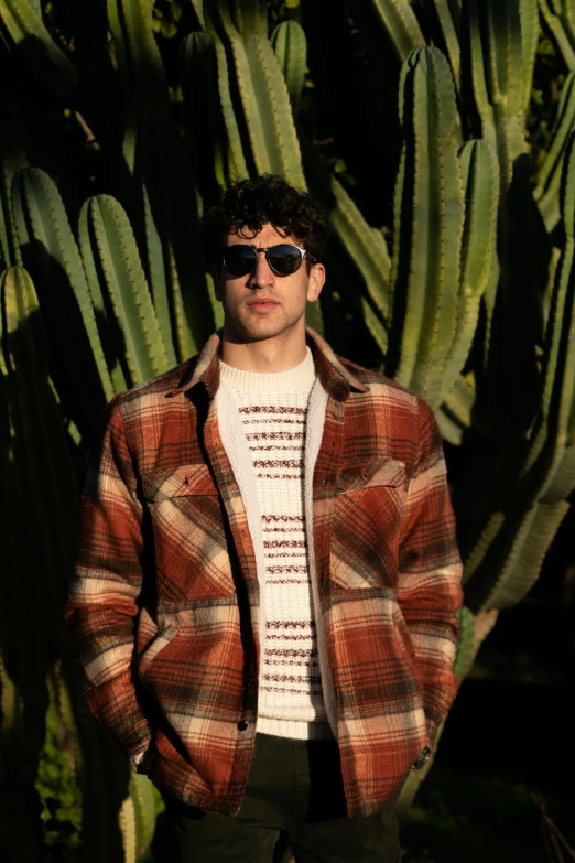 a man is posing for the camera with a jacket over his shoulders