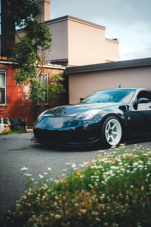 a car parked in front of a house next to a tree