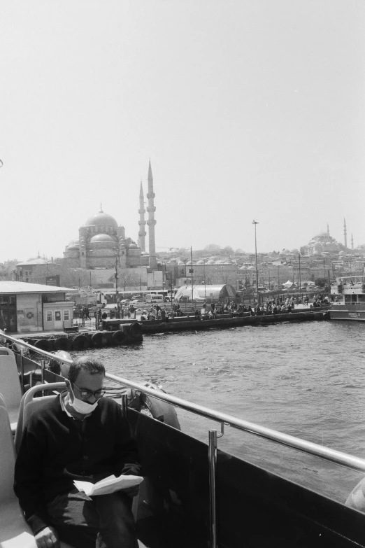 a man sitting next to a large body of water