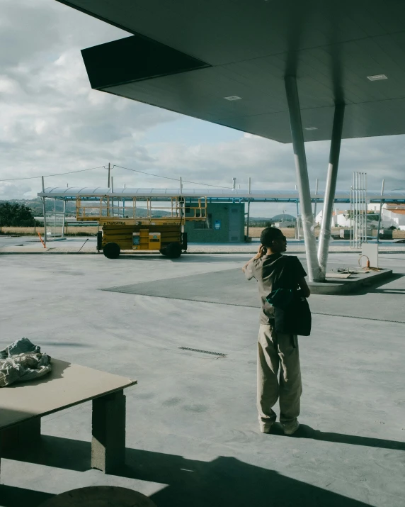 a man standing under an airplane wing in front of a table