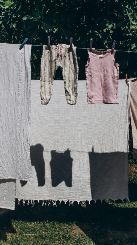clothes hanging up on a line with shadows on the clothes