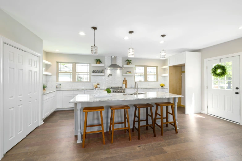 the large kitchen has an island counter and three stools