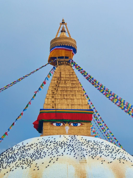 a very tall ornate building with a bird and streamers above it