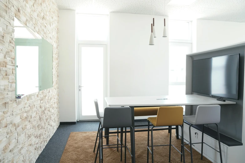 a living room area with counter and chairs and large flat screen tv