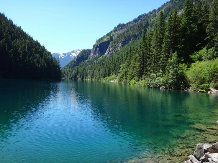 a green lake surrounded by mountains and trees