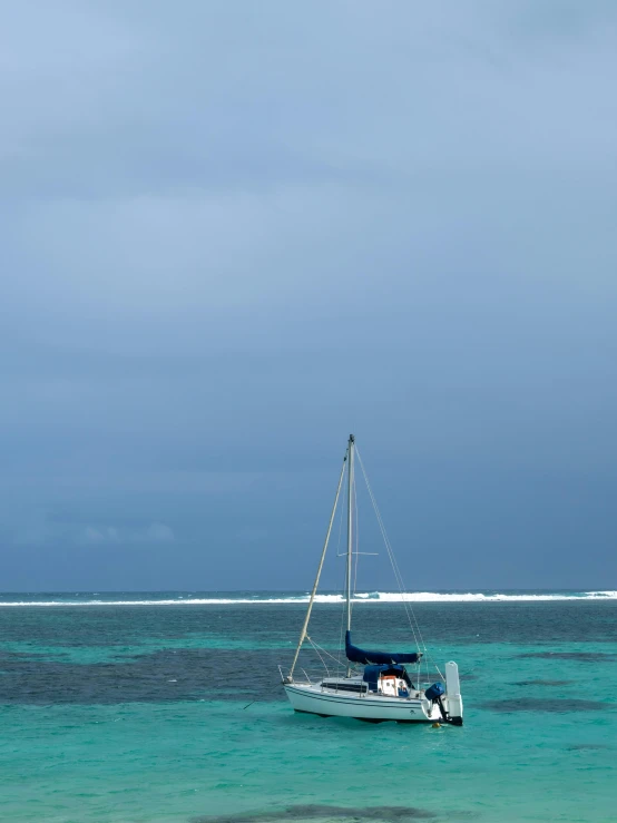 a small boat floating in clear blue waters