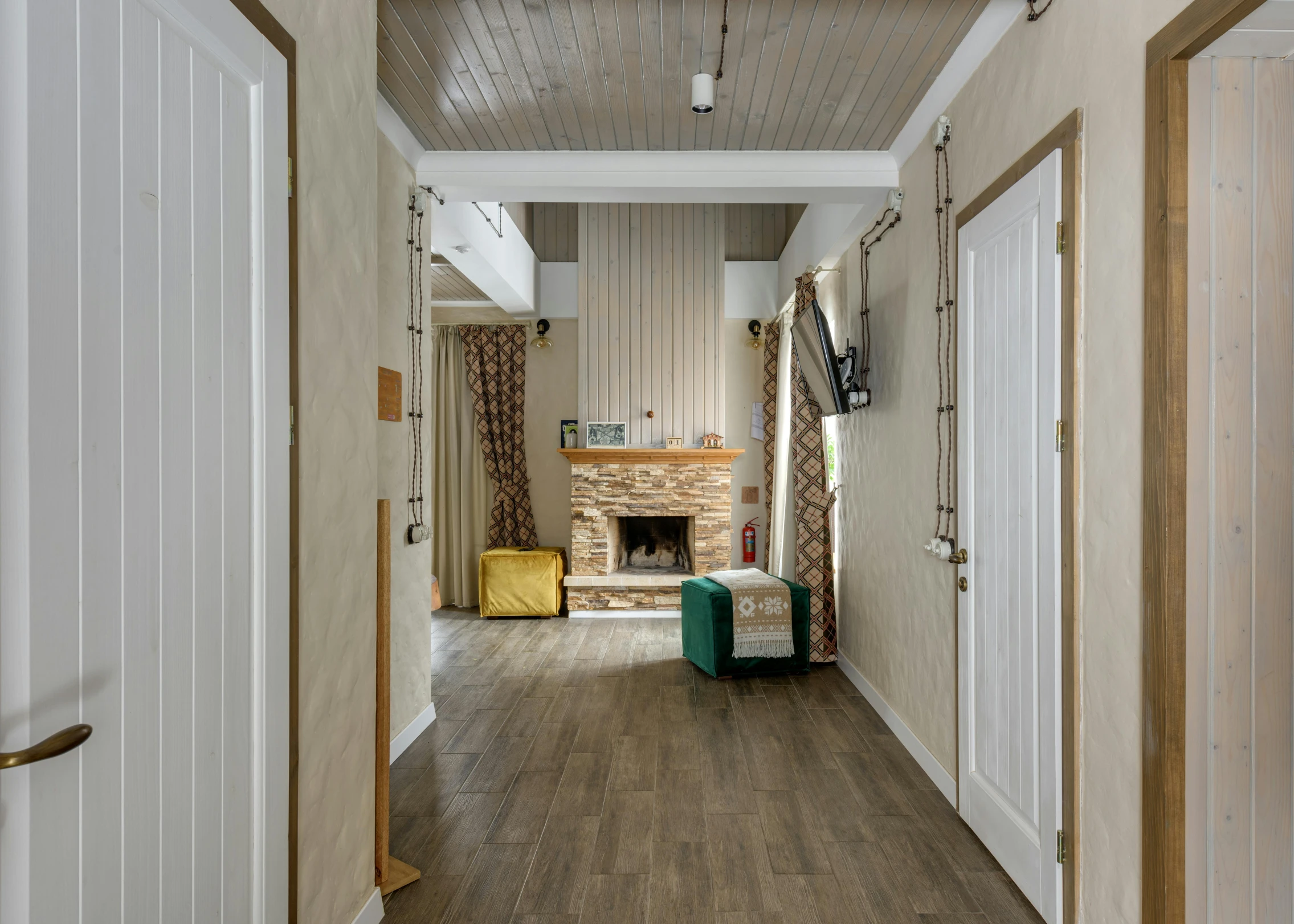 a room with several doors, an open fireplace, and a blue stool