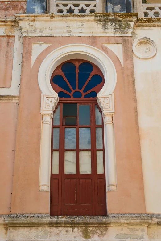 a window that has a red door and is reflecting a clock