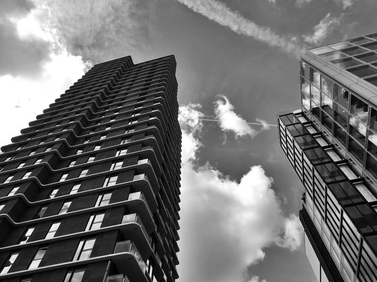 two high rise buildings with jet trails passing by