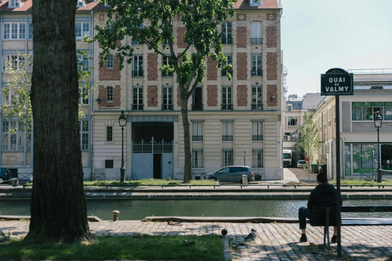 a person sitting on a bench in front of some tall buildings