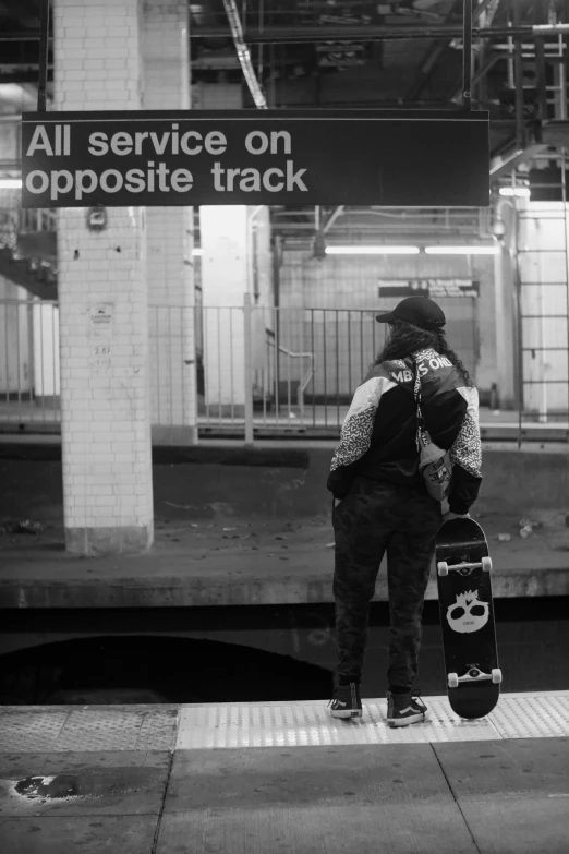 a man holding a skateboard at a platform