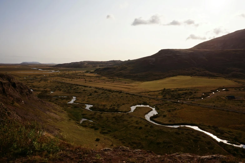 a river running through a lush green mountain valley