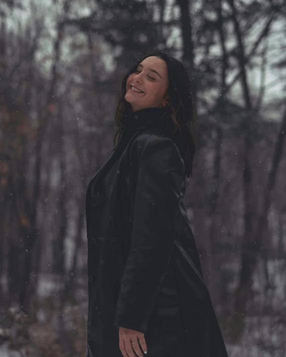 a young woman in black is standing outside