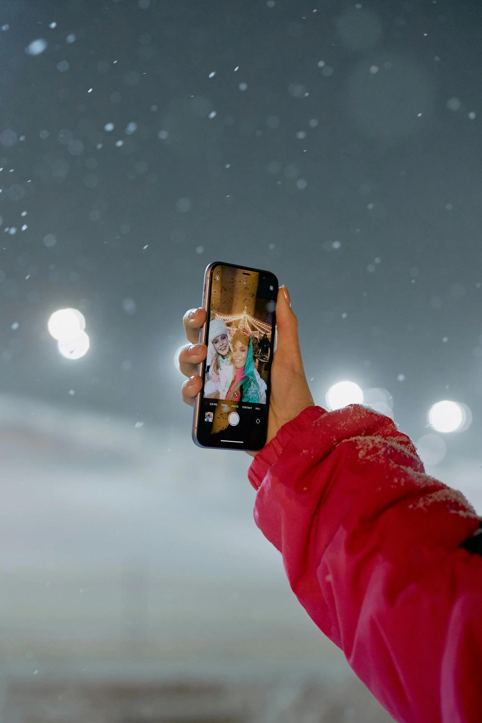 someone taking a po of their cell phone on a snowy night