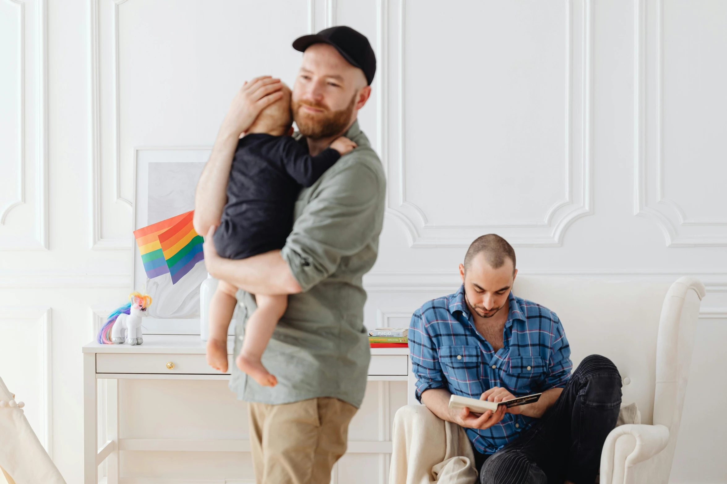 a man is taking his son and talking while playing on his phone